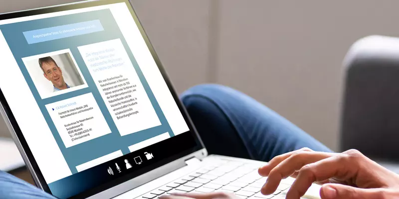 Aufsicht auf ein Laptop mit geöffneter Website der Interessensgemeinschaft „Integrative Liste Bayern“, die sich eine junge Frau anschaut