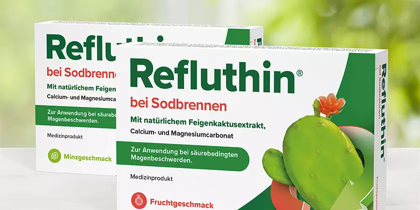 Refluthin®-Packungen auf einem Tisch mit davor liegenden Kautabletten
