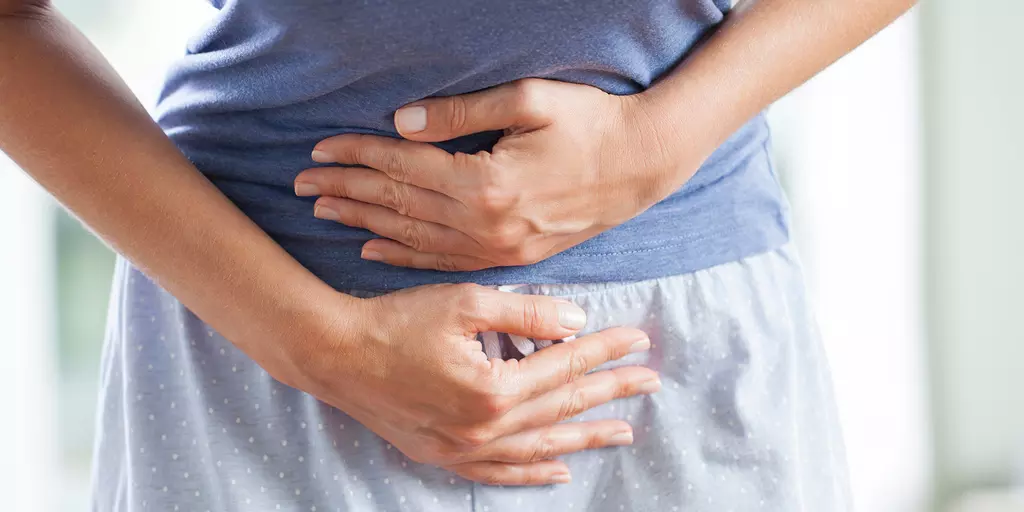 Frau mit Beschwerden hält sich den Bauch