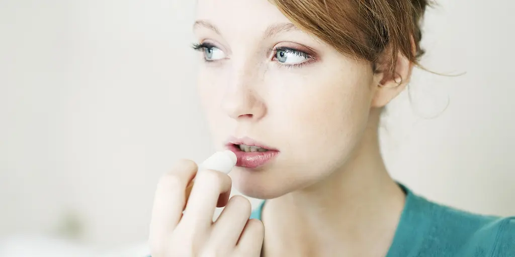 Eine junge Frau pflegt ihre Lippen mit einem Pflegestift