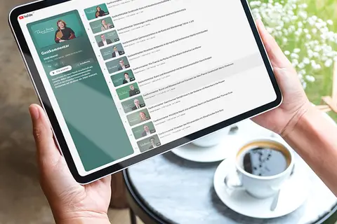 Aufsicht auf ein Tablet mit einer Website zu einer Reihe auf YouTube, dass eine Junge Frau in den Händen hält