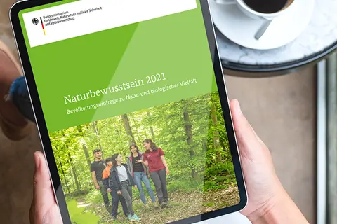 Aufsicht auf ein Tablet mit einer Website zu Naturbewusstsein, dass eine Junge Frau in den Händen hält