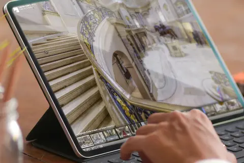 Aufsicht auf ein Laptop mit geöffneter Website des Bode Museums, die sich eine junge Frau anschaut