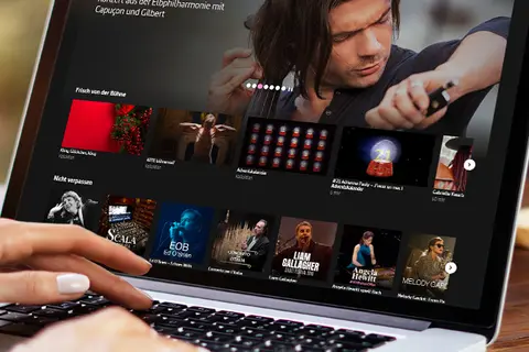 Aufsicht auf ein Laptop mit geöffneter Website des Musikprogramms von arte.tv, auf dem eine Frau auf der Tastatur tippt