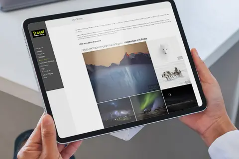 Aufsicht auf ein Tablet mit geöffneter Website "Travel Photographer of The Year", dass eine junge Frau in den Händen hält