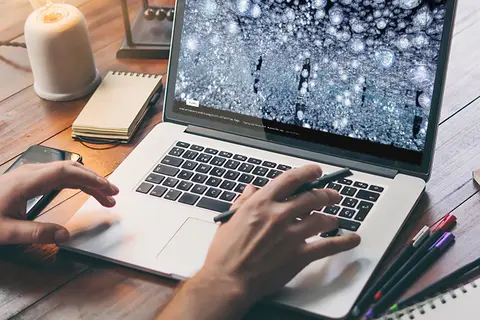 Aufsicht auf ein Laptop mit geöffneter Website des teamLap, die sich eine junge Frau anschaut