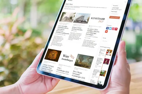 Aufsicht auf ein Tablet mit geöffneter Website artinwords.de, das eine junge Frau in den Händen hält