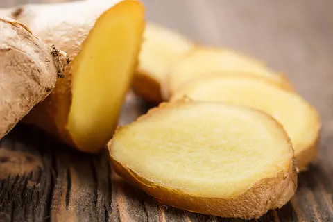 Detail-Ansicht von aufgeschnittenem Ingwer auf einer Holzplatte