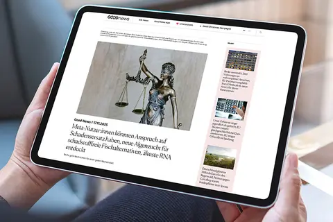 Aufsicht auf ein Tablet mit geöffneter Website goodnews.de, dass eine junge Frau in den Händen hält