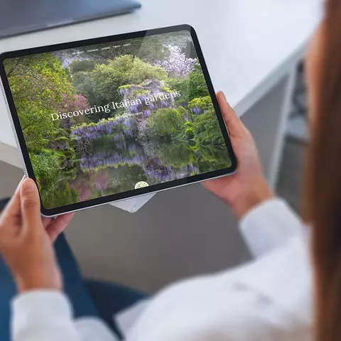 Aufsicht auf ein Tablet mit der Website der Garden Route Italia, dass eine junge Frau in den Händen hält
