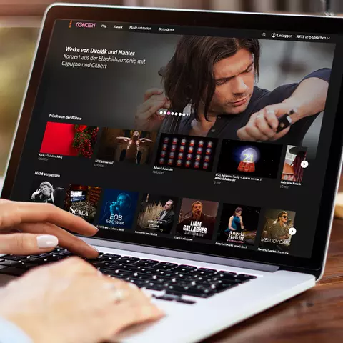 Aufsicht auf ein Laptop mit geöffneter Website des Musikprogramms von arte.tv, auf dem eine Frau auf der Tastatur tippt
