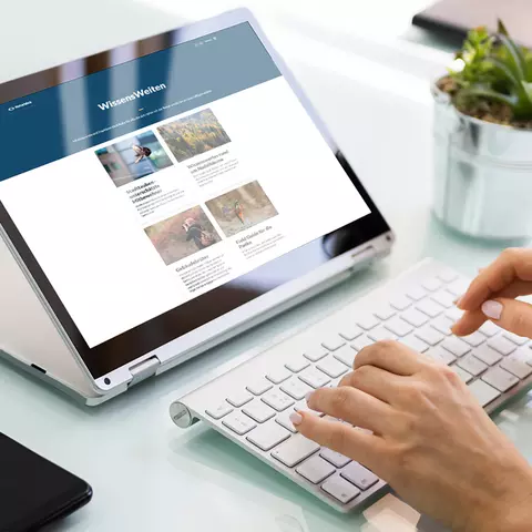Aufsicht auf ein Laptop mit geöffneter Website des Berliner Museums für Naturkunde, die sich eine junge Frau anschaut