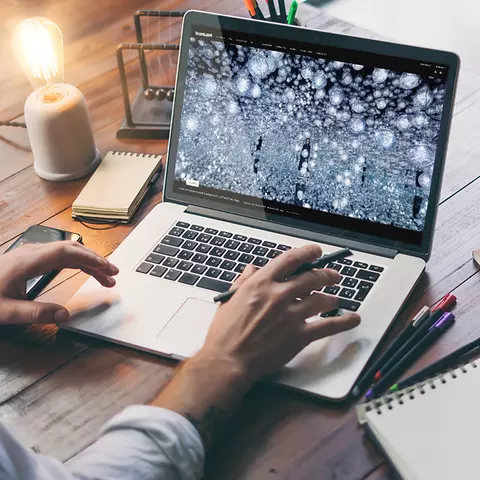 Aufsicht auf ein Laptop mit geöffneter Website des teamLap, die sich eine junge Frau anschaut