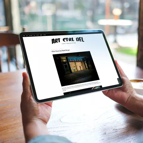 Aufsicht auf ein Laptop mit geöffneter Website ART CTRL DEL, die sich eine junge Frau anschaut