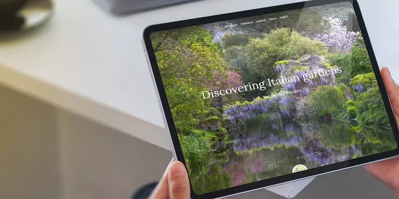 Aufsicht auf ein Tablet mit der Website der Garden Route Italia, dass eine junge Frau in den Händen hält