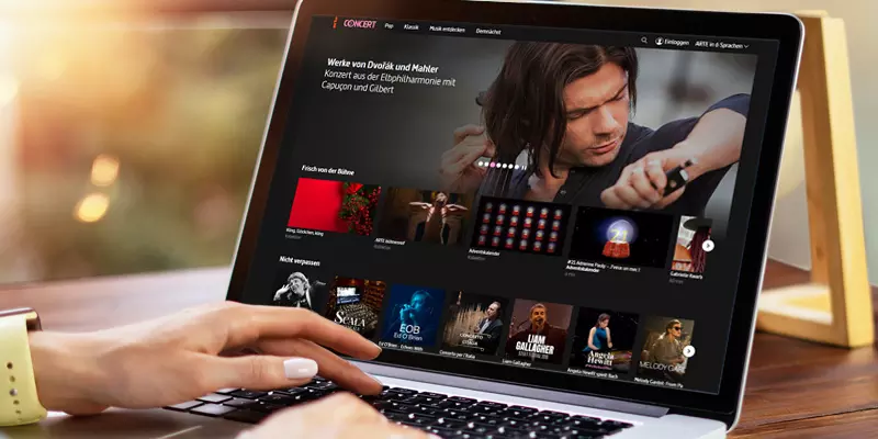 Aufsicht auf ein Laptop mit geöffneter Website des Musikprogramms von arte.tv, auf dem eine Frau auf der Tastatur tippt