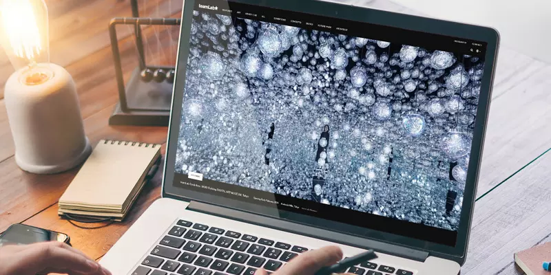 Aufsicht auf ein Laptop mit geöffneter Website des teamLap, die sich eine junge Frau anschaut
