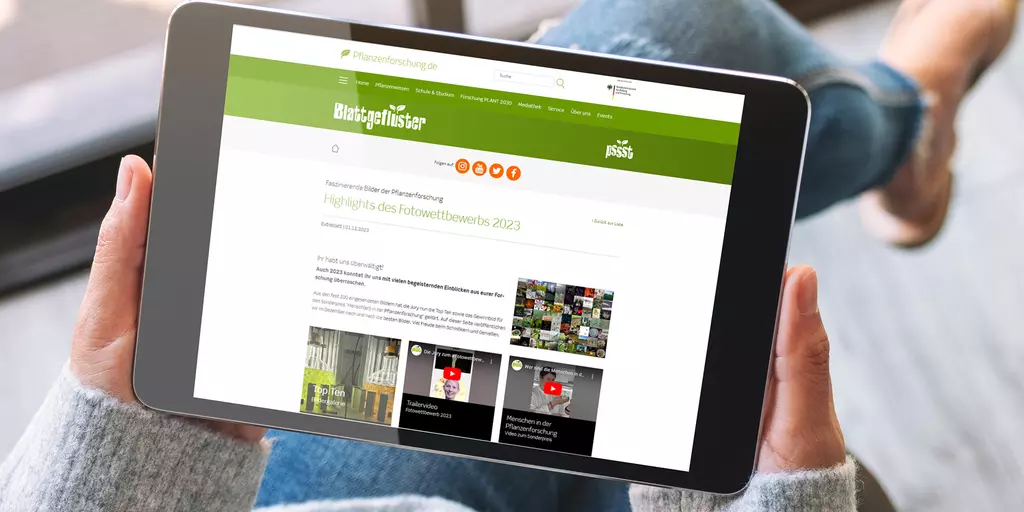 Aufsicht auf ein Tablet mit geöffneter Website des Blattgeflüster Fotowettbewerbs 2023, dass eine junge Frau in den Händen hält