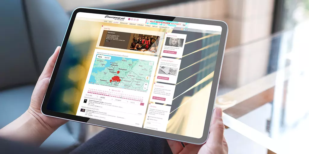 Aufsicht auf ein Tablet mit geöffneter Website classicpoint.net, dass eine junge Frau in den Händen hält