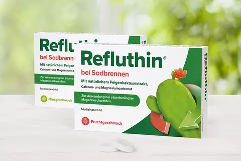Refluthin®-Packungen auf einem Tisch mit davor liegenden Kautabletten