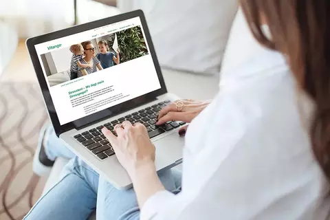 Eine junge Frau macht an ihrem Laptop den Vitango® Selbsttest "Stress"