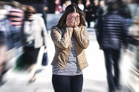 Überforderte Frau in einer Menschenmenge