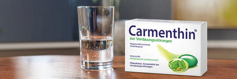 Carmenthin Packung und ein Wasserglas auf einem Tisch stehend