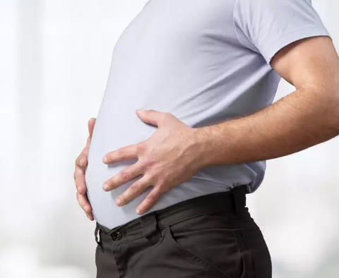 Mann hält sich den Bauch wegen Völlegefühl