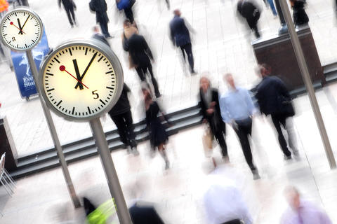 Menschenmenge in einer Fußgängerzone mit mehreren Standuhren
