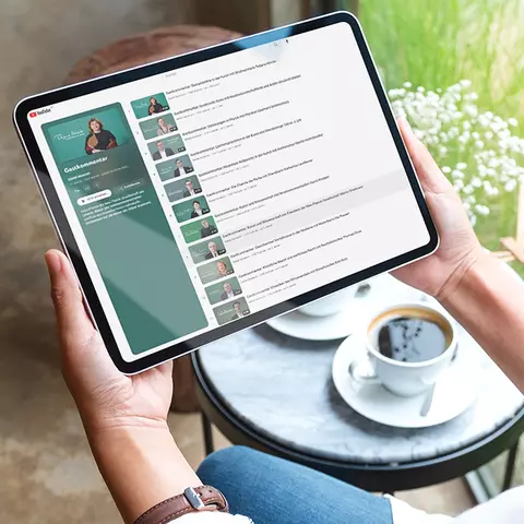 Aufsicht auf ein Tablet mit einer Website zu einer Reihe auf YouTube, dass eine Junge Frau in den Händen hält
